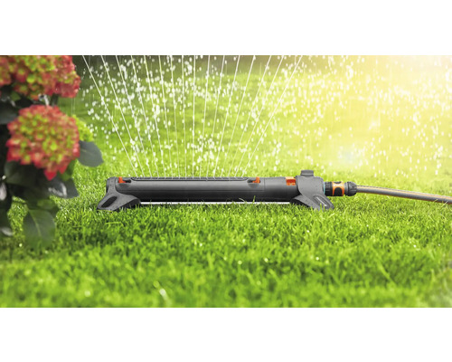 Grässpridare i drift på en grön yta