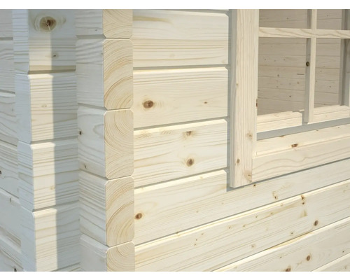 Detaljvy av en trävägg med fönsterkarm från ett trädgårdshus