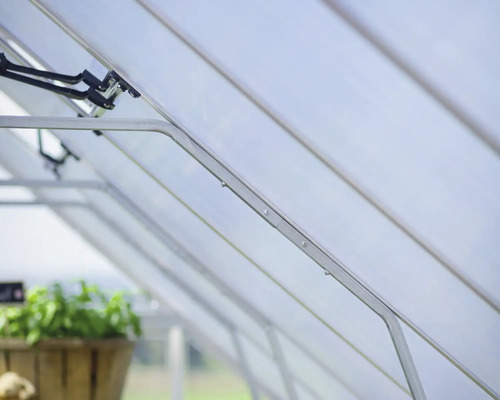 Interiör av ett växthus med ram och paneler.