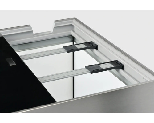 Detaljvy av ett hyllsystem med en svart hylla, aluminiumskenor och svarta fästen.