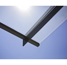 Detaljvy av ett terrasstak i glas och metall mot en blå himmel