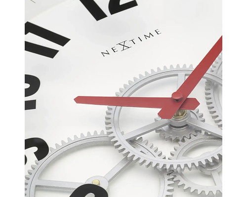 Närbild av en Nextime väggklocka med synlig urmekanism och röda visare