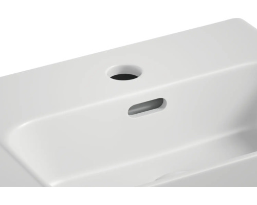 Detaljvy av tvättställ med kranhål och överfyllnadsskydd