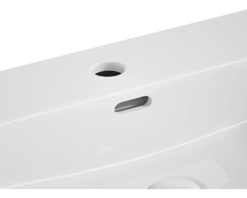 Detaljvy av ett tvättställ med kranhål och överfyllnadsskydd