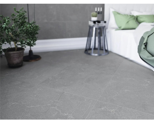 Gråa plattor i sovrum med säng och växt