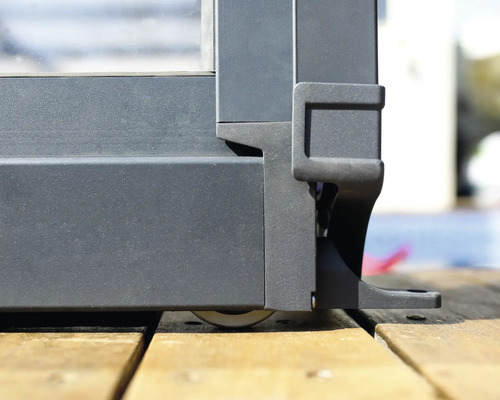 Detaljvy av en trädgårdsstaketstolpe med rullfot på ett trägolv