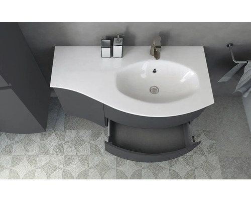 Badrumsskåp med öppen låda, kran och handdukshållare i ett badrum