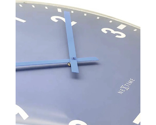 Närbild av en Nextime väggklocka med urtavla och visare