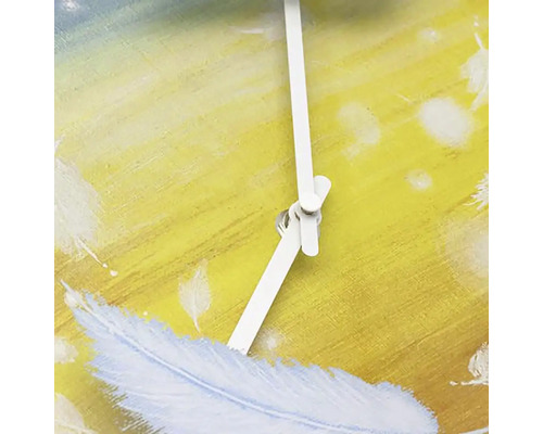 Närbild av en väggklocka med fjäderdesign och vita visare.