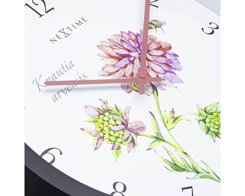 Detaljvy av en väggklocka med blommotiv och tidsvisning