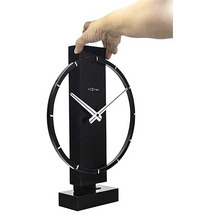 Nextime bordsklocka med cirkelformad design hålls av en hand.