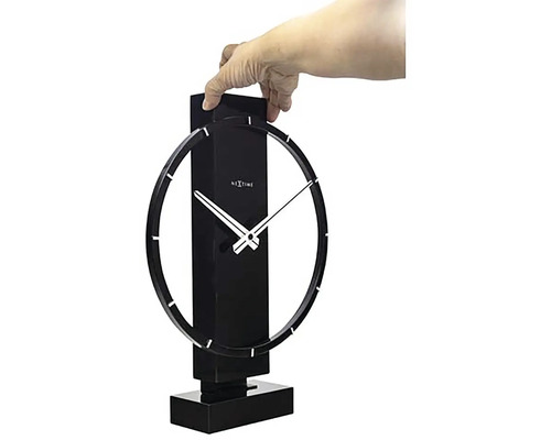 Nextime bordsklocka med cirkelformad design hålls av en hand.