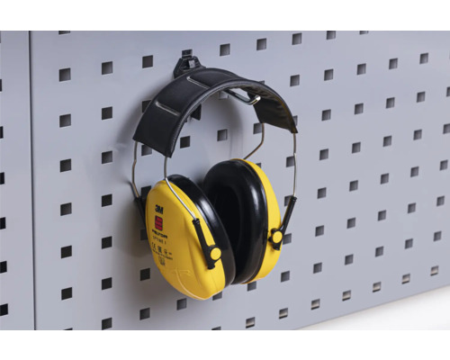 Gula 3M Peltor Optime I hörselkåpor hänger på en perforerad vägg