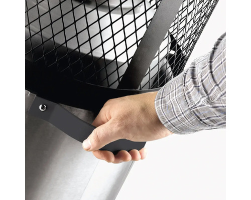 Detaljvy av eldfat med hand på handtaget