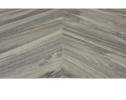 Närbild av ett vinylgolv i fiskbensmönster med träutseende.