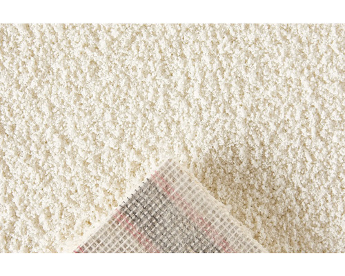 Detaljvy av en beige matta med hög lugg