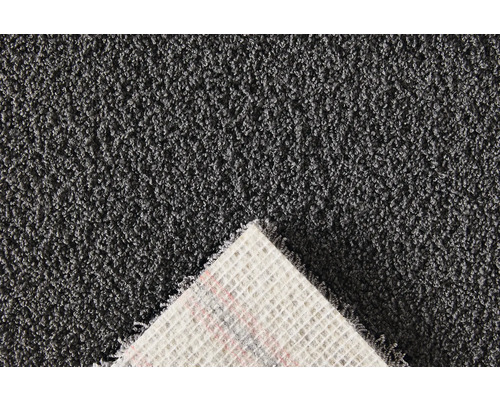 Detaljvy av en grå matta med lugg och textilbaksida