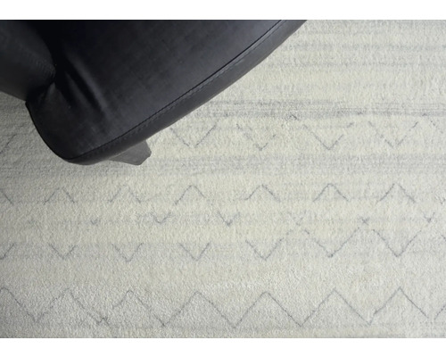 Matta med sicksackmönster under en möbel