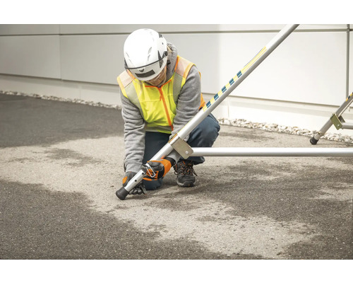 En person monterar en byggnadsställning med nivellerande fötter.