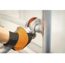 En person fäster ett ställningsrör med en rörkoppling