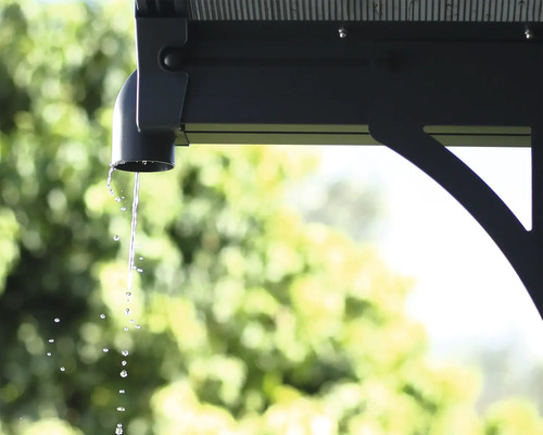 Detaljvy av en takränna på en byggnad med vatten som rinner av