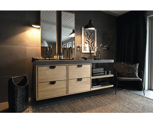 Badrum med tvättställ, spegel och dekoration i mörka toner