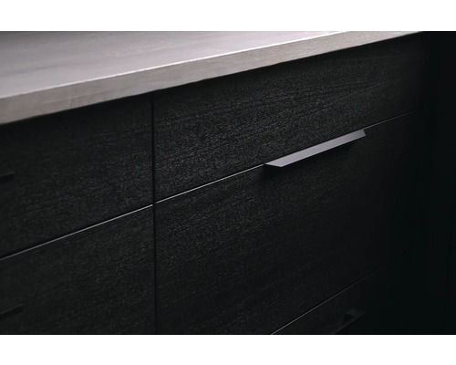 Närbild av ett mörkt träskåp med lådor och handtag