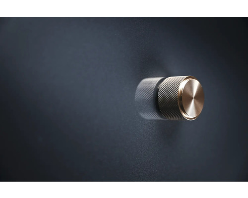 Metallisk vridknapp på mörk yta