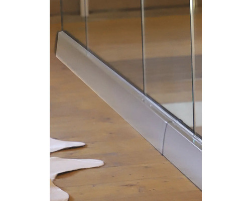 Närbild av en duschkabin med metallram på ett trägolv