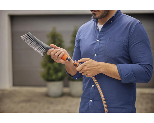 Man ansluter borste till trädgårdsslang