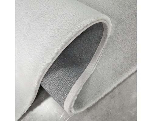 Detaljvy av en ljusfärgad matta med lugg