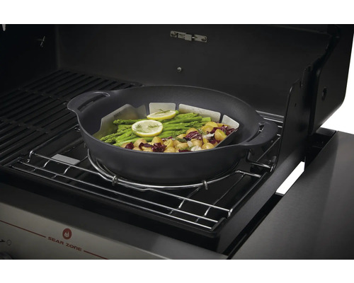 Grönsakspanna med grönsaker och citron på en grill