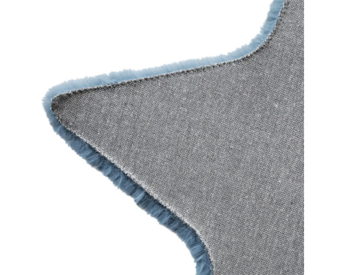 Detaljvy av en stjärnformad matta med textil undersida och fransar