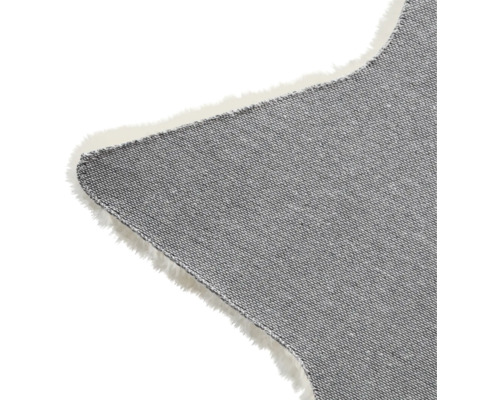 Detalj av en grå stjärnformad matta med fransar