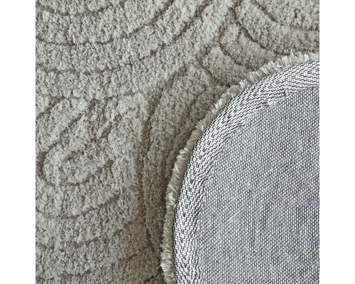 Detalj av en rund matta med mönster och fransar