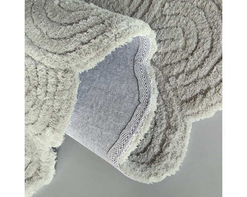 Närbild av en grå badrumsmatta med spiralmönster