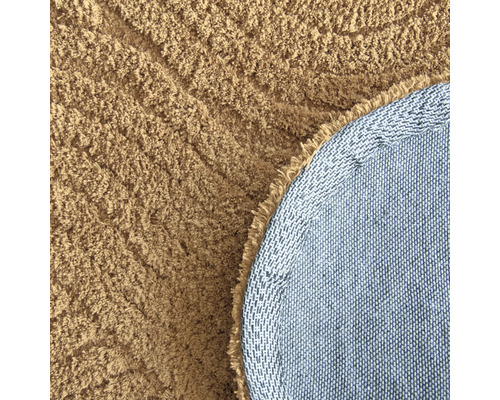 Detaljvy av en rund matta med lugg och vävd baksida