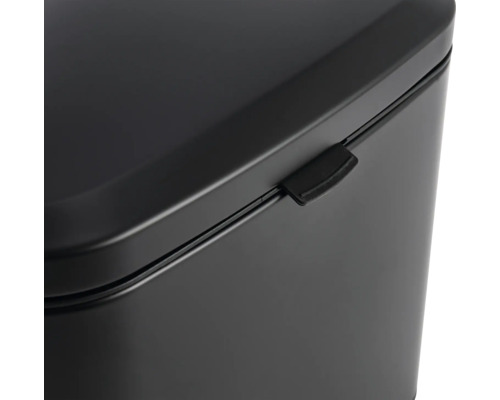 Detaljvy av en svart soptunna med lock och stängningsmekanism.