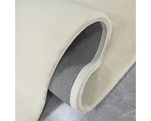 Detaljvy av en beige matta med lugg