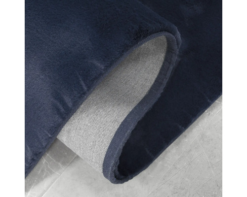 Detaljvy av en mörkblå matta med textilbaksida