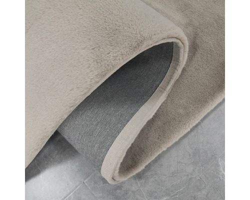 Detaljvy av en beige matta med lugg