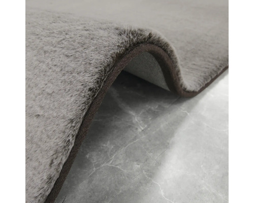 Detaljvy av en grå matta med brun kant