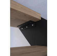 Detaljvy av ett svart vägghyllfäste som stöder en trähylla.