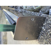 Detaljvy av ett glasräckesfäste i metall med skruvar