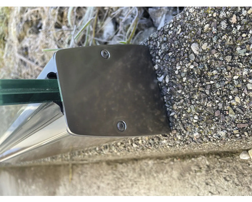 Närbild av ett glasräckesfäste med skruvar