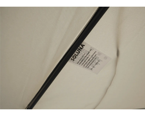 Detaljvy av ett Soluna parasoll med tillverkarens etikett