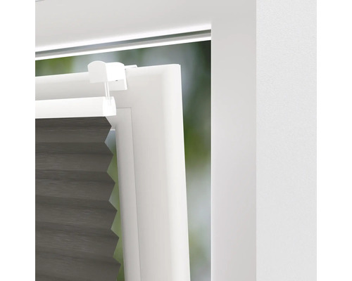 Detaljvy av en antracitfärgad plisségardin på ett fönster