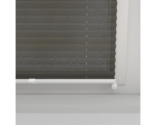 Grå plisségardiner vid fönstret