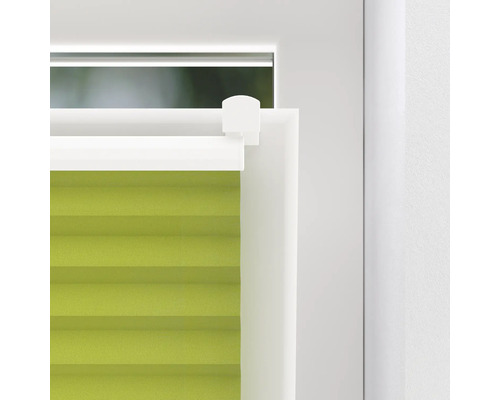 Närbild av en grön plisségardin i fönstret