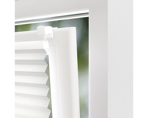 Detaljvy av en vit plisségardin i fönstret